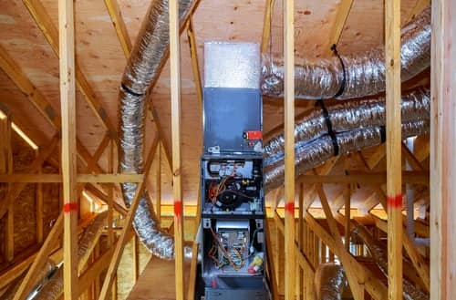 Attic framing with ductwork and mechanical equipment prepared for spray foam insulation and air sealing