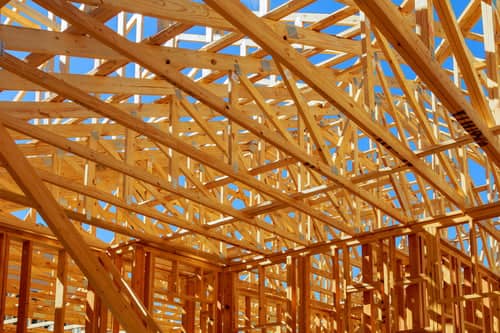 Roof truss framing viewed from inside a new construction attic where spray foam insulation will be applied