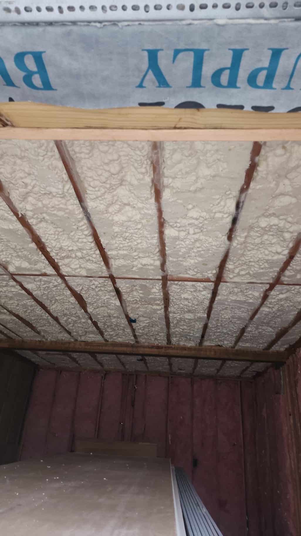Open cell spray foam insulation sprayed between exposed roof deck joists in a commercial or residential framing project